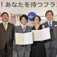 Bicycle racer Yukiya Arashiro (third from left) and freelance announcer Eriko Nakamura (third from right), after being named France 2016 sightseeing goodwill ambassadors, pose with \"France Sightseeing Campaign 2016\" partners, from left, Shigeru Fukui, H.I.S. Co.; Frederic Mazenq, director in Japan of Atout France; French Ambassador Thierry Dana; and Stefan Vanovermeir, general manager for Japan, Air France and KLM at a press conference at the ambassador\'s residence in Tokyo on March 24. | YOSHIAKI MIURA