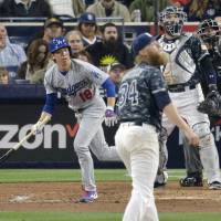 Los Angeles Dodgers pitcher Kenta Maeda, appearing in his first regular-season MLB game, belts a solo home run in the fourth inning off San Diego Padres hurler Andrew Cashner on Wednesday. Maeda pitched six scoreless innings and earned the victory in the Dodgers\' 7-0 triumph in San Diego. | KYODO