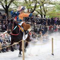 A mounted archer, with his horse running a full gallop, releases his arrow. The goal is to hit the target three consecutive times. | SATOKO KAWASAKI