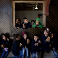 Syrian refugees eat outside their classroom at a makeshift school, where only Syrian students are enrolled, built by NGO Kayany Foundation in Saadnayel, Lebanon, on May 12. The leaders of the Group of Seven are likely to discuss, among other subjects, providing sufficient education to refugee children. | AP