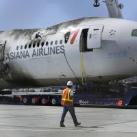 A man looks at the wreckage of Asiana Flight 214 at San Francisco International Airport in 2013. San Francisco city leaders approved a $3.45 million settlement Tuesday from Asiana Airlines involving a fiery 2013 airport crash that killed three people and injured nearly 200 others. The city attorney had called the proposed settlement the final chapter in the tragedy caused when Asiana Flight 214 clipped a seawall on approach to San Francisco International Airport and burst into flames on the runway. San Francisco OKs $3.45 million settlement over deadly 2013 Asiana crash