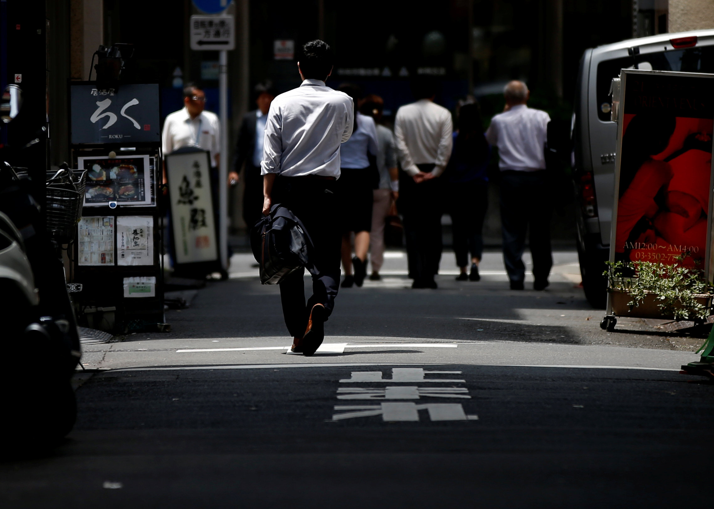 Pedestrians walk through a Tokyo business district on Tuesday. Japan's job availability rose to the highest level in over 24 years. | REUTERS