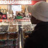 A woman waits to buy doughnuts at a Krispy Kreme shop in Washington, DC, on Monday. UKrispy Kreme is being bought by the German investment group JAB Holding, folding it into JAB’s strong portfolio of European and North American coffee and coffee-shop brands. Sweet $1.35 billion takeover offer gives Krispy Kreme shares caffeine spike