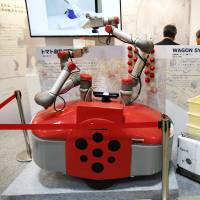 A tomato-harvesting robot developed by Squse Inc. is displayed at the International Robot Exhibition in Tokyo last year. | BLOOMBERG
