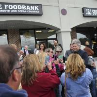 Rock star and philanthropist Jon Bon Jovi (right) has his photo taken with fans at his Jon Bon Jovi Soul Foundation’s grand opening for the B.E.A.T. Center, which stands for Bringing Everyone All Together, Tuesday, Tuesday in Toms River, New Jersey. The center is designed as a one-stop facility to help people get food stamps, health care and culinary-related job training. It also provides meals for at-risk children and seniors. Bon Jovi opens center to feed hungry in Superstorm Sandy-hit coastal town