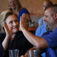 Democratic presidential candidate Hillary Clinton high fives Scott Conley while speaking to steelworkers in Ashland, Kentucky, Monday. | AP