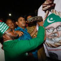 A Bangladeshi man throws a shoe at a Motiur Rahman Nizami poster to celebrate the execution of the Jamaat-e-Islami party\'s senior leader outside Dhaka\'s central jail early Wednesday. Nizami is the fifth man to be hanged as three other senior colleagues from his Islamist party and another senior leader of main opposition Bangladesh Nationalist Party led by former Prime Minister Khaleda Zia have been hanged since 2013. | AP