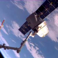 This May 11, 2016, NASA TV frame grab shows the SpaceX Dragon cargo ship at the end of the Canada arm prior to release for departure from the International Space Station. | AFP-JIJI