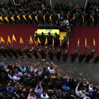 Hezbollah fighters carry the coffin of their slain commander Mustafa Badreddine, draped in a Hezbollah flag, who was killed in Syria, during his funeral procession in a southern suburb of Beirut on Friday. | AP