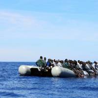 Migrants sit in their boat during a rescue operation by the Italian navy ship Grecale (unseen) off the coast of Sicily in this handout picture courtesy of the Italian Marina Militare released on May 6. | MARINA MILITARE / HANDOUT VIA REUTERS