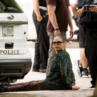 A woman is detained in Lafayette Park near the White House along Pennsylvania Avenue, in Washington, Monday. Secret Service spokesman Robert Hoback says someone at about 12:15 p.m. threw a metal object over the north fence along Pennsylvania Avenue and was arrested without incident. He did not identify the person, though a witness saw a woman placed in handcuffs. | AP