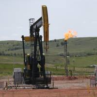 Natural gas burns off behind oil pumps in Watford City, North Dakota. | AP
