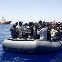 African migrants on a dinghy are approached by the Search and Rescue team of SOS MEDITERRANEE during an operation in the Mediterranean sea May 16. | GIORGOS MOUTAFIS / SOS MEDITERRANEE VIA AP