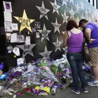 People pay their respects at a memorial for music superstar Prince in Minneapolis on Thursday. | AP