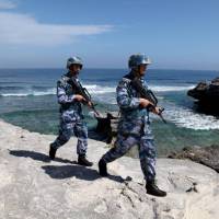 China\'s People\'s Liberation Army Navy soldiers patrol on Woody Island, in the Paracel archipelago of the South China Sea, in January. | REUTERS