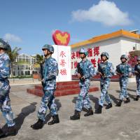 People\'s Liberation Army Navy soldiers patrol at Fiery Cross Reef in the Spratly chain of the South China Sea in February. | REUTERS