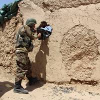 An Afghan National Army (ANA) soldier mans his position at an outpost in Babaji area of Lashkar Gah Helmand province, Afghanistan, Sunday. | REUTERS