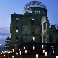 Paper lanterns glow in front of the A-bomb Dome at Hiroshima\'s Peace Memorial Park on August 6, 2000. | REUTERS