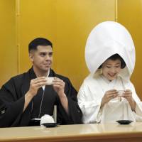 Jonathan Madrid and Nao Sasaki rehearse drinking nuptial cherry blossom tea together before their wedding ceremony at Meiji Jingu Shrine in Tokyo on Saturday. | YOSHIAKI MIURA