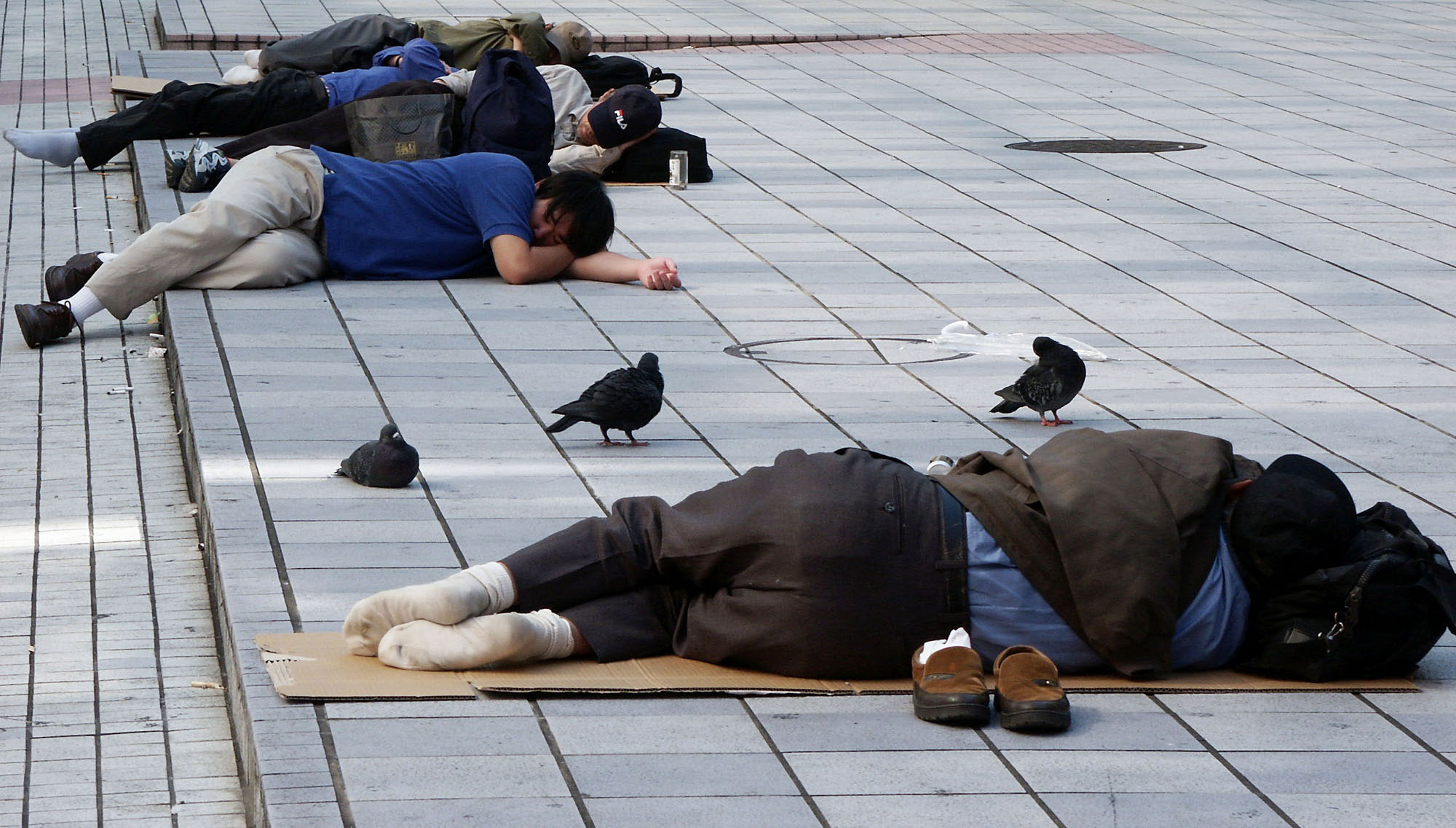 Homeless and unemployed people sleep in the Kabukicho district in Tokyo. | BLOOMBERG