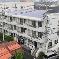 Police stand outside an apartment on Wednesday where a man identified as Kazuhiro Honda took a woman in her 20s hostage Tuesday night. The suspect was later arrested and the hostage freed. | KYODO