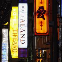 Neon signs hang from the exterior of love hotels in the Kabukicho entertainment district of Tokyo. | BLOOMBERG NEWS