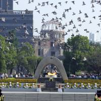 Doves fly over Hiroshima\'s Peace Memorial Park with a view of the gutted A-bomb dome at a ceremony on Aug. 6, 2006. | REUTERS