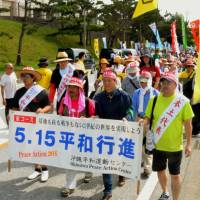 Protesters march in front of Camp Schwab in Nago, Okinawa Prefecture, on Friday ahead of the 44th anniversary Sunday of Okinawa\'s reversion to Japan. | KYODO