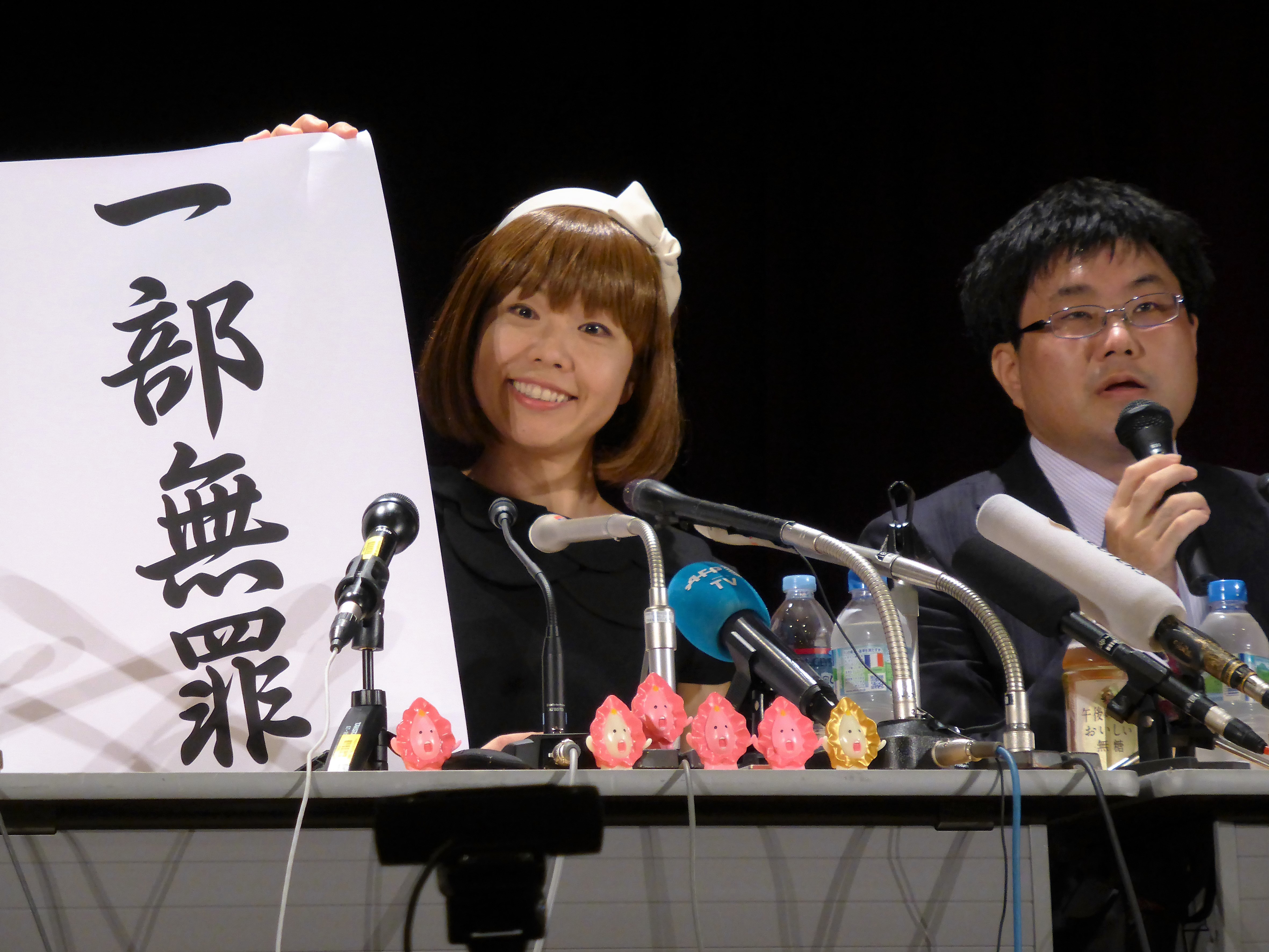Megumi Igarashi, 44, addresses reporters on Monday with a banner that says 'partially innocent.' | SHUSUKE MURAI