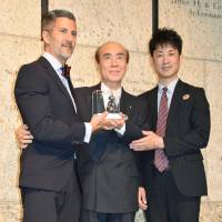 Masahiro Sasaki (center), the elder brother of Sadako, an iconic victim of the 1945 atomic bombing in Hiroshima, donates a paper crane to the Japanese American National Museum in Los Angeles Sunday. | KYODO