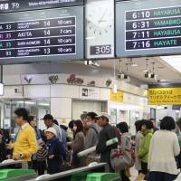 Bullet train passengers who were trapped aboard a Tohoku Shinkansen Line train for five hours by a fatal accident arrive at Morioka Station early Sunday. | KYODO