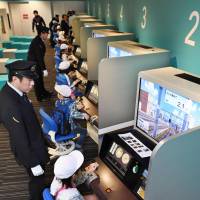 Elementary school pupils try out train simulators at the Kyoto Railway Museum in Kyoto on April 15. The facility opened to the public last Friday. | KYODO