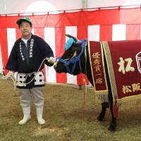 A farmer stands alongside a cow named Momomiya, which attracted the highest bid at an auction in 2015. | J.J. O’DONOGHUE