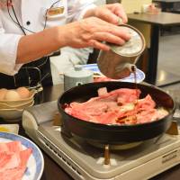 A waitress prepares a hot plate of Matsusaka beef in sukiyaki in Maruyoshi in the city of Matsusaka, Mie Prefecture. | J.J. O’DONOGHUE
