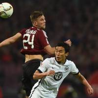 Eintracht Frankfurt\'s Makoto Hasebe vies for the ball with Nuremburg\'s Niclas Fuellkrug during their promotion-relegation playoff second leg on Monday. | AFP-JIJI