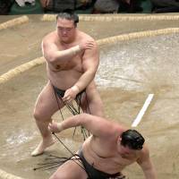 Kisenosato throws Goeido out of the ring at the Summer Grand Sumo Tournament at Ryogoku Kokugikan on Monday. | KYODO