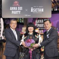 Designer Anna Sui (center) poses with Hiroshi Ohnishi (left), president and CEO of Isetan Mitsukoshi Holdings Ltd., and Masaaki Takano, Isetan Shinjuku managing executive officer and general manager, to celebrate the 20th anniversary of the designer entering the Japan market during the opening ceremony of the \"ANNA SUI PARTY,\" at the Isetan Shinjuku Main Store on May 4. | YOSHIAKI MIURA