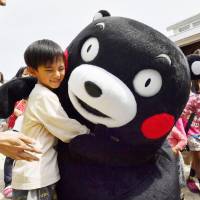 Kumamon delights children in the village of Nishihara, Kumamoto Prefecture, on Thursday. The prefectural mascot was kept out of sight after deadly quakes upended residents\' lives last month, but the prefectural government wheeled him out to cheer up stressed-out kids on Children\'s Day. | KYODO