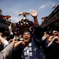 A mikoshi (portable shrine) is carried around Sensoji Temple as the three-day Sanja festival concludes in Tokyo\'s Asakusa district Sunday. The event was inspired by the discovery of a Buddhist statue in the Sumida River 1,388 years ago. | REUTERS