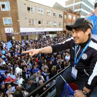 Leicester City striker Shinji Okazaki joins teammates aboard an open-top bus Monday in the English city in celebration of the 132-year-old soccer club\'s first-ever Premier League title. | GETTY / KYODO