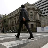 A businessman walks past the Bank of Japan headquarters in Tokyo. | REUTERS