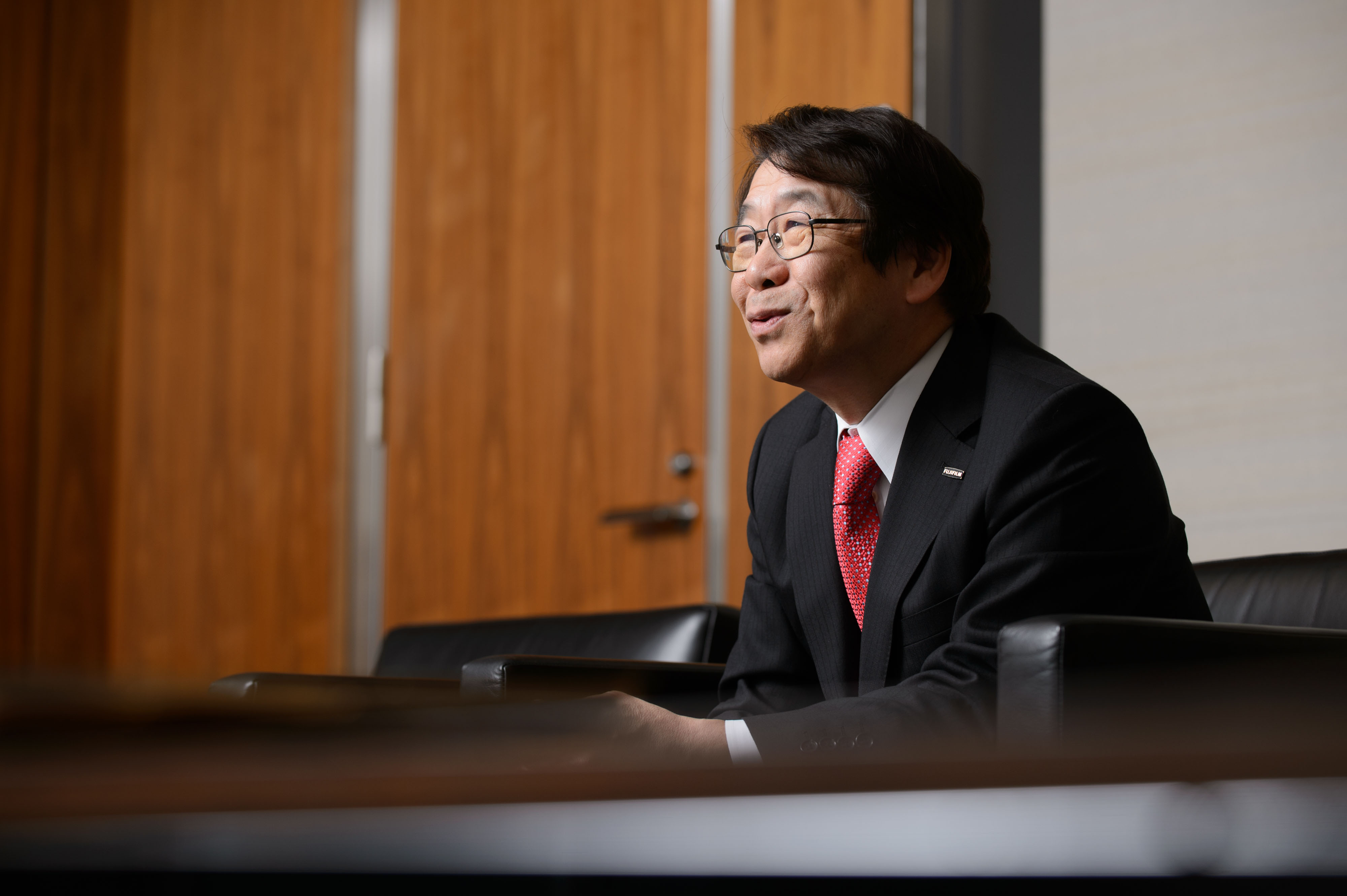 Kenji Sukeno, president of Fujifilm Holdings Corp., is interviewed in Tokyo on Thursday. Fujifilm is targeting 20 percent operating margins in its drug operations and aims to make the business profitable in the fiscal year starting April 2018, he said. | BLOOMBERG