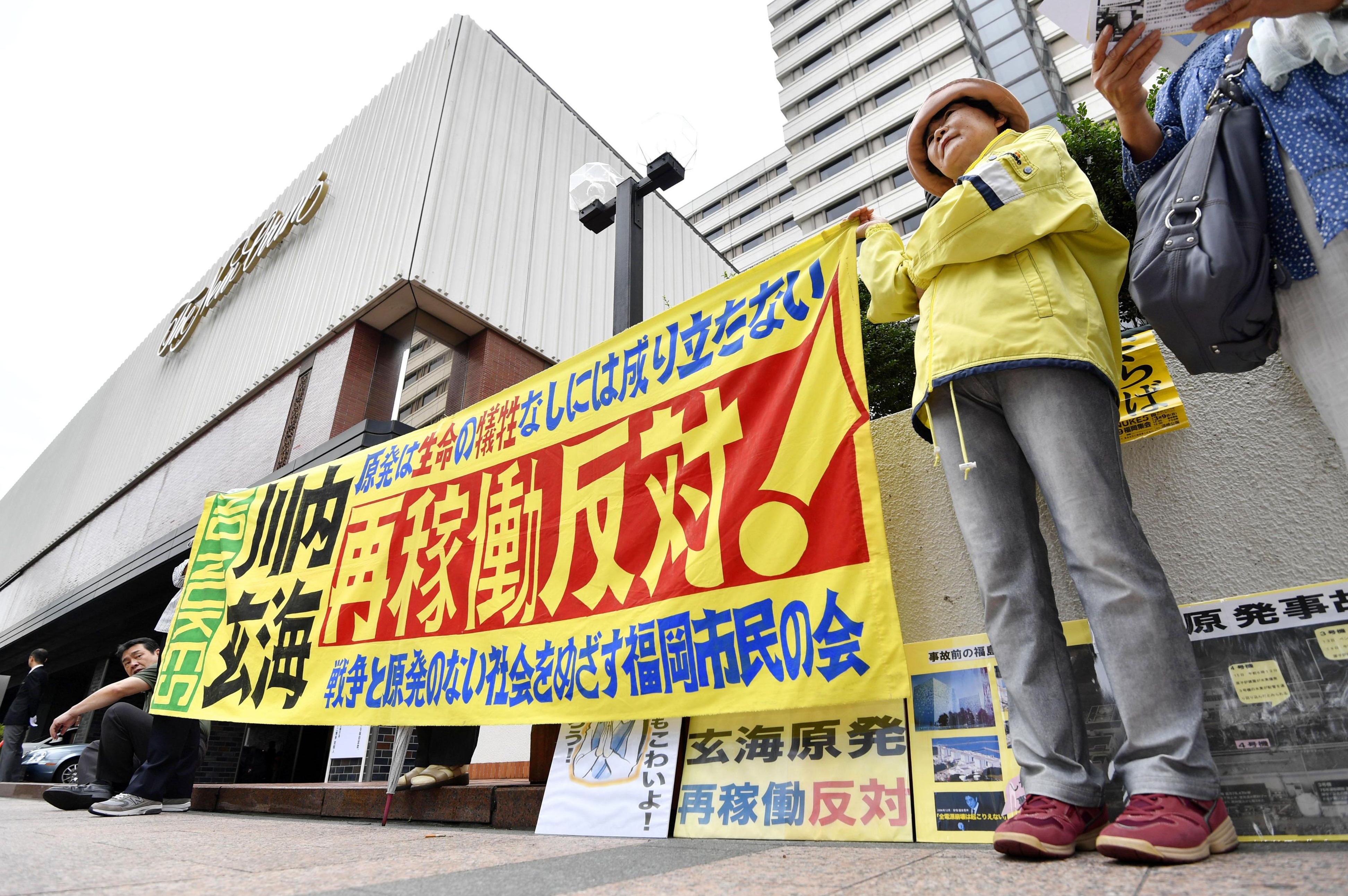 People protest against the recent restart of Kyushu Electric Power Co.'s Sendai nuclear power plant near the utility's shareholders meeting in Fukuoka Prefecture on Tuesday. | KYODO