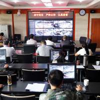 A surveillance team monitors Chinese students by camera during their college entrance exam on Tuesday in Zhengzhou, Henan province. | AFP-JIJI