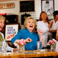 Hillary Clinton shares a laugh with Rep. Laura Capps during a campaign stop on Saturday at a restaurant in Santa Barbara, California. | REUTERS
