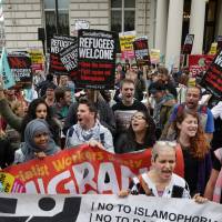 Activists rally at the French Embassy in London on Saturday in protest at the rejection by French authorities of a convoy that tried to deliver aid to migrants in Calais, France. Some migrants are risking their lives crossing a shipping channel to reach Britain. | AFP-JIJI