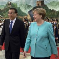 German Chancellor Angela Merkel attends a welcome ceremony in Beijing with Chinese Premier Li Keqiang. | AP