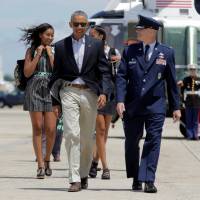 U.S. President Barack Obama and his daughters, Malia and Sasha, walk with first lady Michelle Obama (unseen) to Air Force One at Joint Base Andrews in Maryland on Friday. | REUTERS