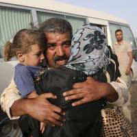 An Iraqi soldier targeted by Islamic State extremists, who destroyed his home two years ago, is reunited with his family outside Fallujah on Friday. Except for the Mideast, the world grew more peaceful last year, according to the 2016 Global Peace Index. | AP