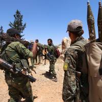 Fighters of the Syria Democratic Forces (SDF) walk in the western rural area of Manbij, near Aleppo, Syria, on June 13, 2016. | REUTERS